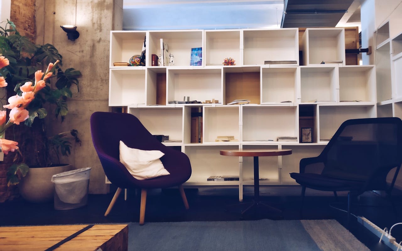 About A stylish living room featuring modern furniture, bookshelves, and decorative plants.